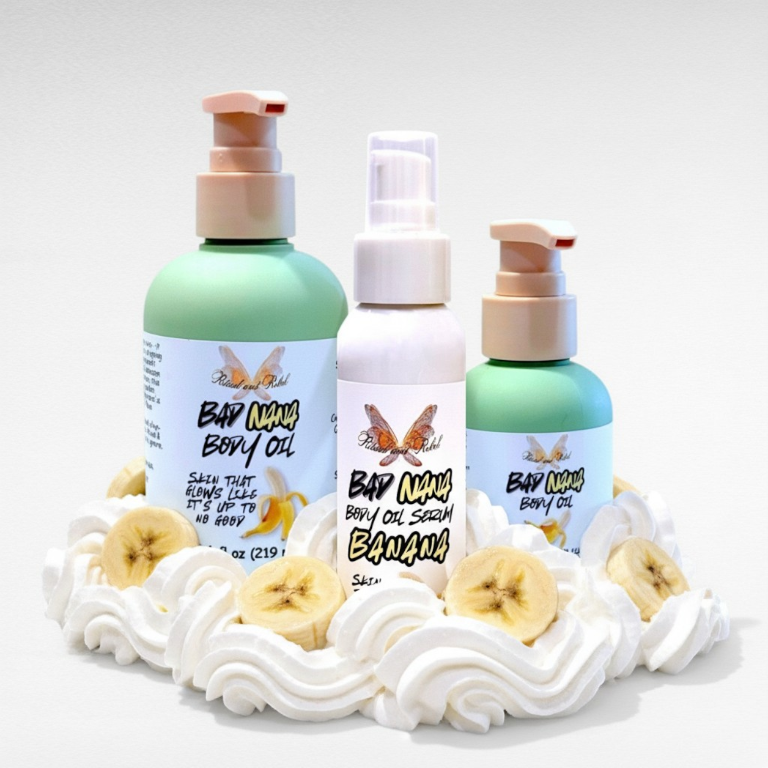 Bad Nana Body Oil by Ritual and Rebel 3 bottles with pumps surrounded by whipped cream and bananas 