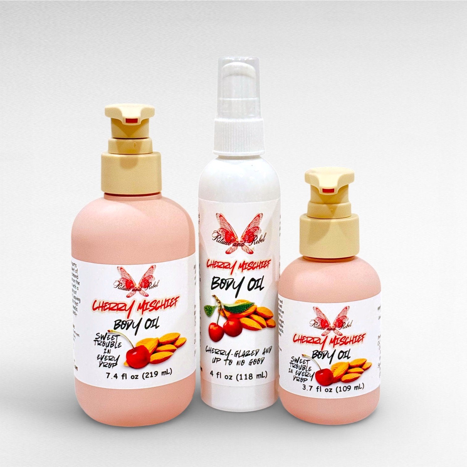 Cherry Mischief Body Oil by Ritual and Rebel 2 pink pump bottles with pumps and white bottle with serum pump