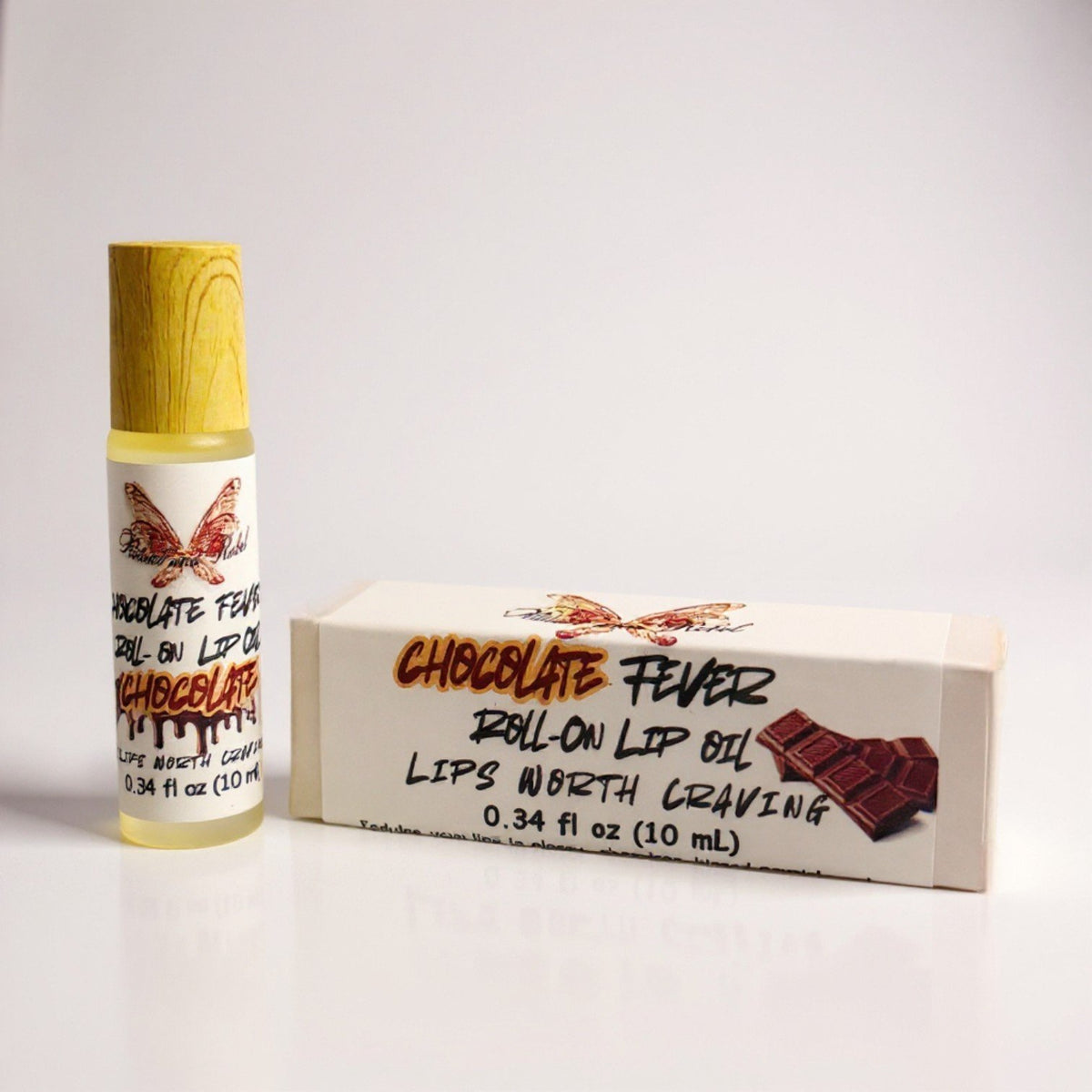 Chocolate Fever lip oil by Ritual and Rebel Roll-on lip oil with wooden applicator and packaging labeled 'Chocolate Fever' on a white background