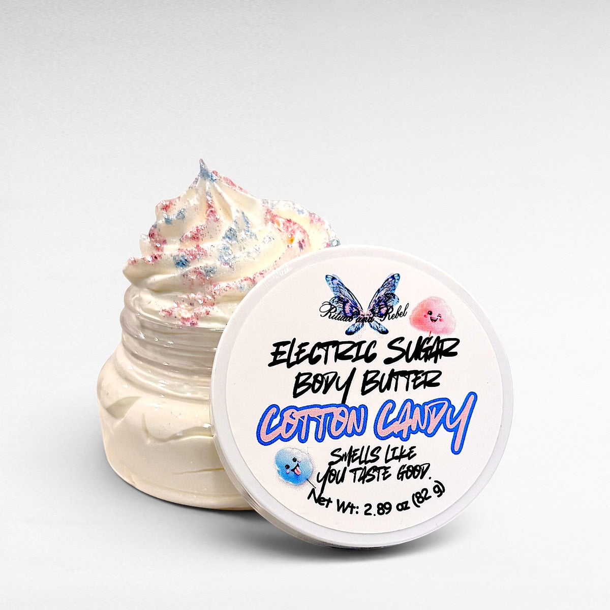 Electric Sugar Body Butter by Ritual and Rebel cream colored whipped body butter in clear plastic jar with pink and blue glitter mica on top and white round lid 2.89 oz
