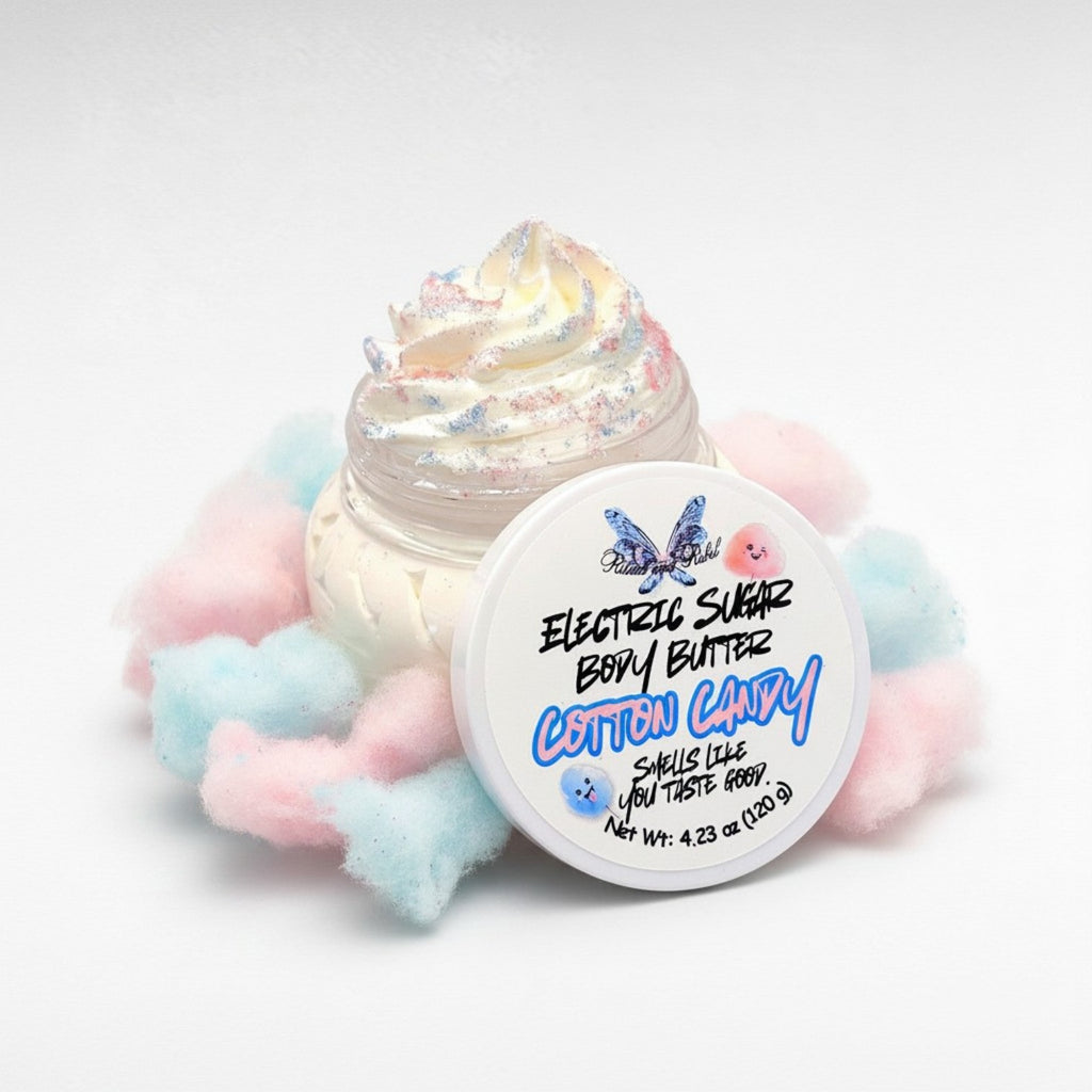 Electric Sugar Body Butter by Ritual and Rebel cream colored whipped body butter in clear plastic jar with pink and blue glitter mica on top and white round lid and cotton candy pink and blue around base of jar