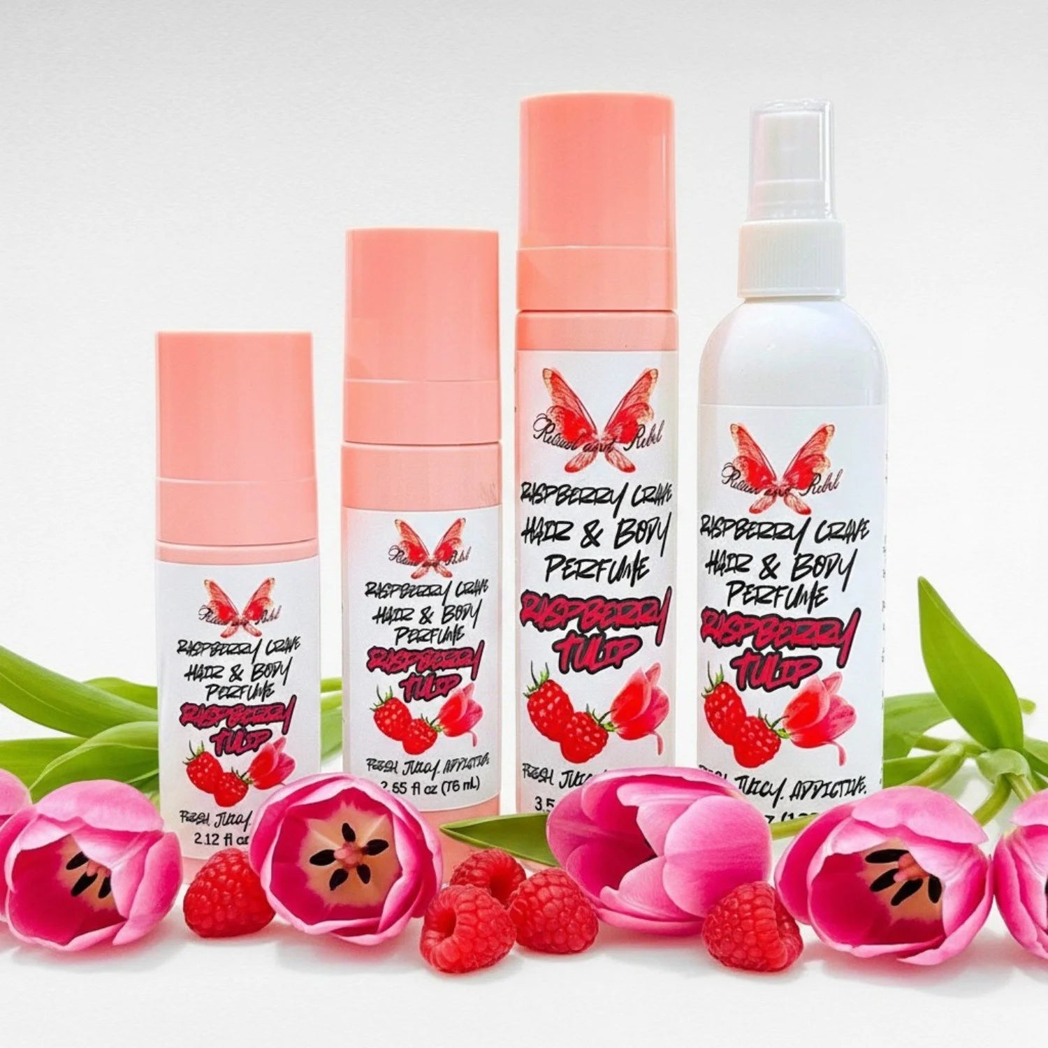Raspberry Tulip hair and body perfume by Ritual and Rebel set of 3 pink spray bottles and 1 white spray bottle of various sizes with raspberries and tulips surrounding bottles