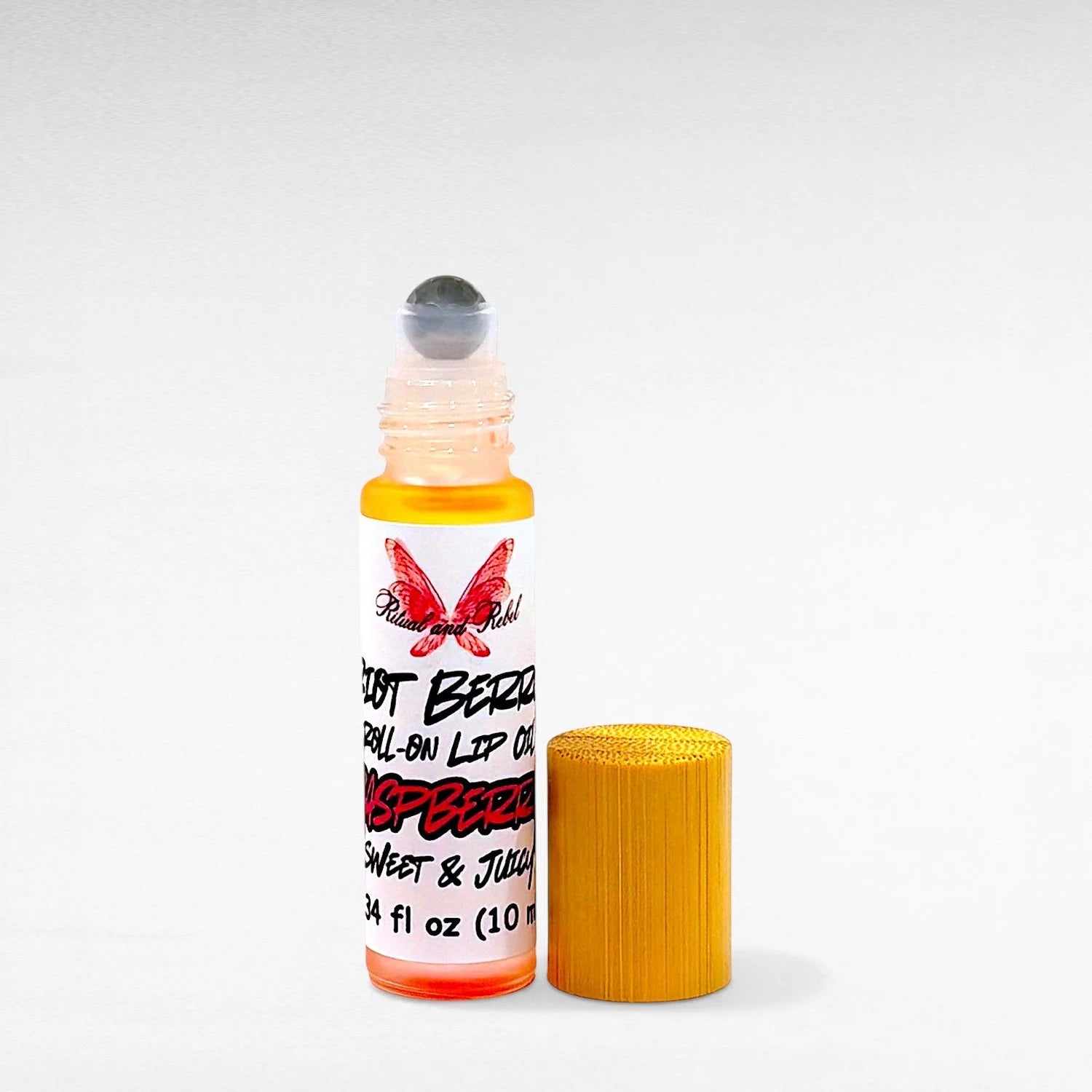 Riot Berry Roll On Lip Oil by Ritual and Rebel glass bottle with metal roll on ball with wood bamboo lid 10 ml