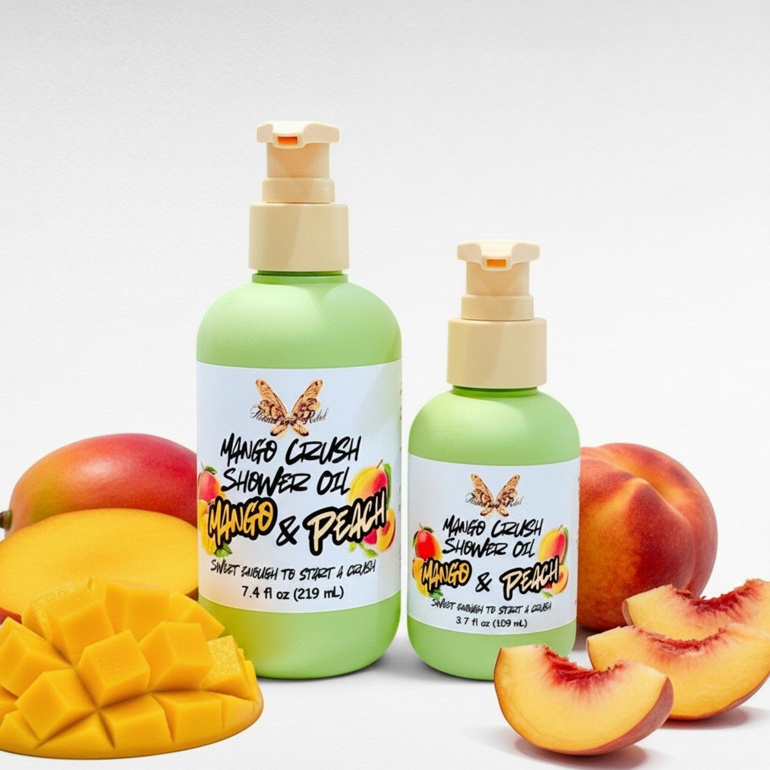 Ritual and Rebel Mango Crush Shower Oil bottles in two sizes surrounded by fresh mango and peach slices.