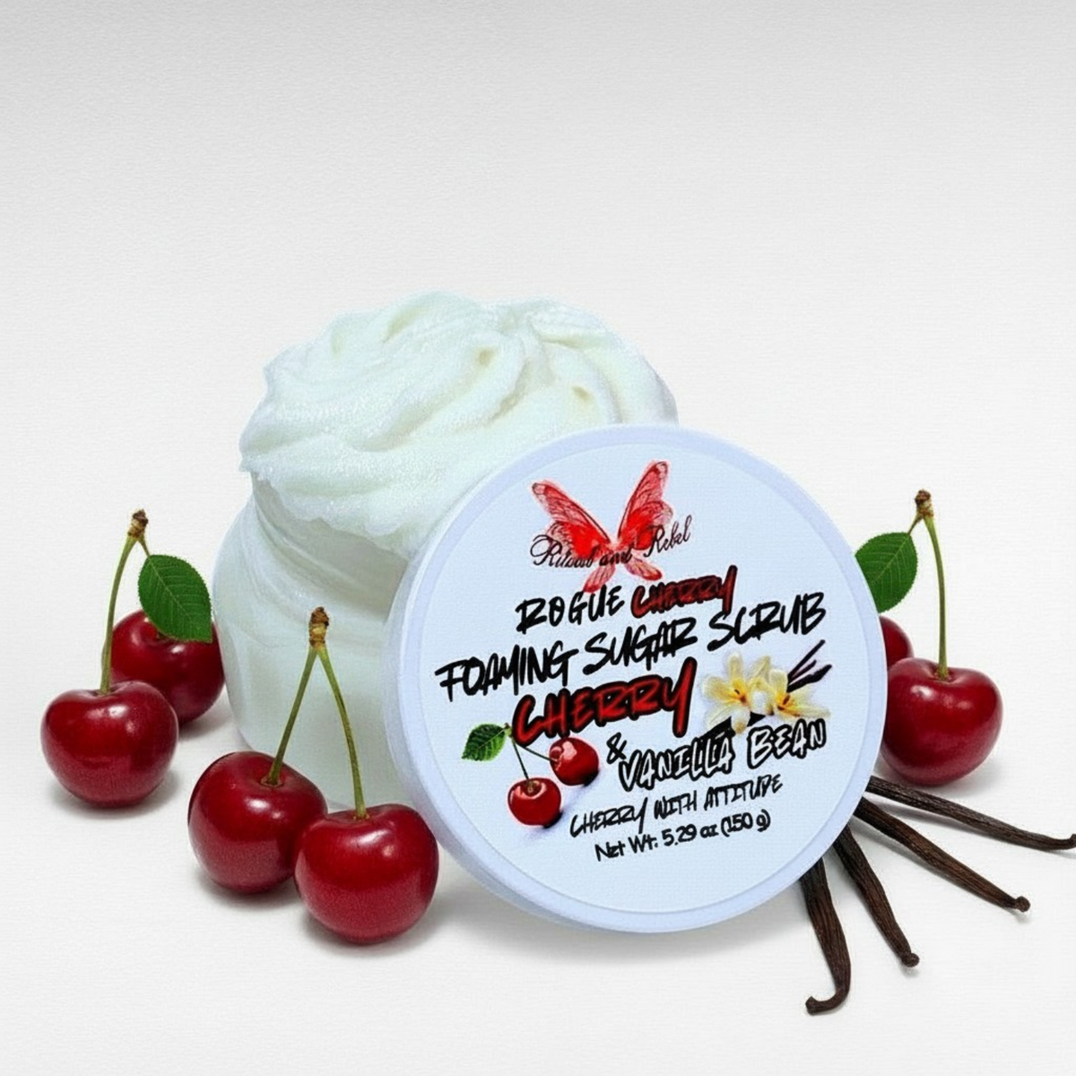 Rogue Cherry Foaming Sugar Scrub clear plastic jar with white lid and label with cherries and vanilla beans surrounding jar by Ritual and Rebel 5.29 oz