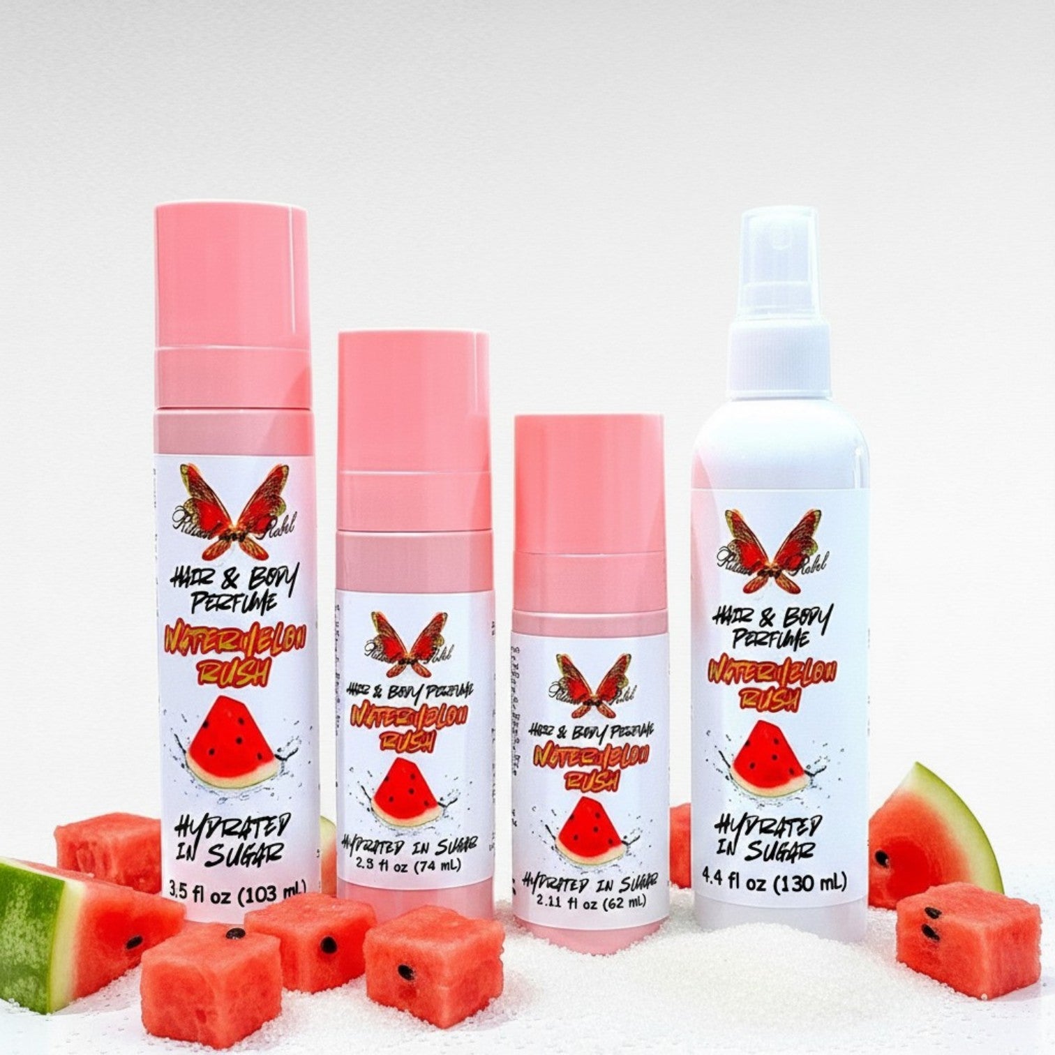 Watermelon Rush Hair & Body Perfume by Ritual and Rebel 3 pink bottles and 1 white spray bottle with slices of watermelon and sugar around base of bottles