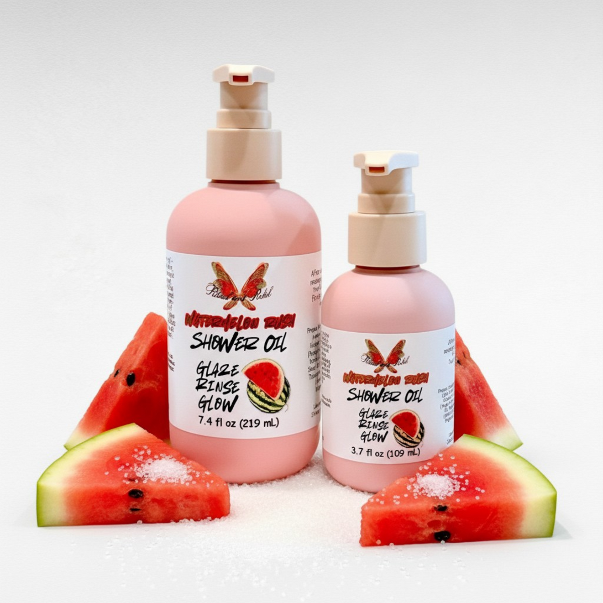 Watermelon Rush Shower Oil by Ritual and Rebel 2 pink bottles with beige pumps and watermelon with sugar around bottles